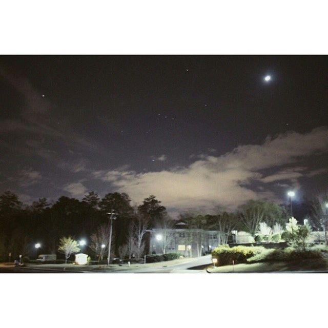 night, illuminated, transfer print, sky, auto post production filter, street light, building exterior, tree, built structure, street, architecture, road, lighting equipment, outdoors, weather, city, dusk, light - natural phenomenon, cloud - sky, moon