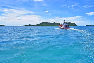 Boat sailing in sea against blue sky