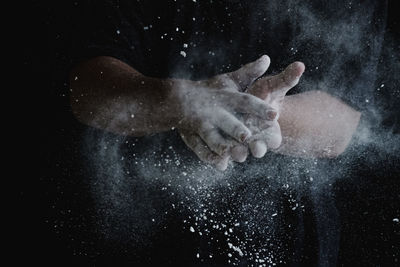 Close-up of human hand against black background