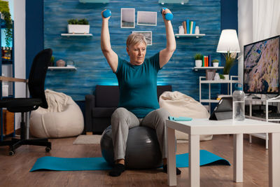 Full length of man sitting on sofa