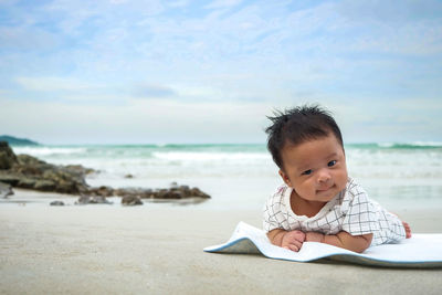 Portrait of boy on beach against sky