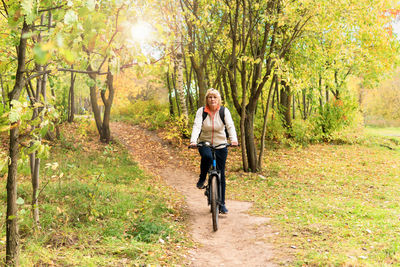 Full length portrait of woman walking in forest