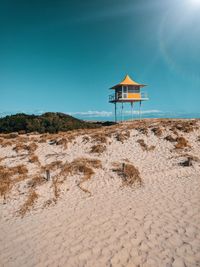 Lifeguard hut on beach against clear blue sky