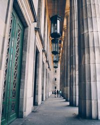 Rear view of people walking in alley amidst buildings