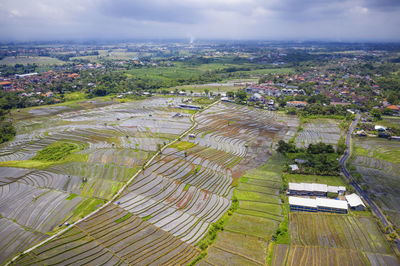 High angle view of field and cityscape against sky