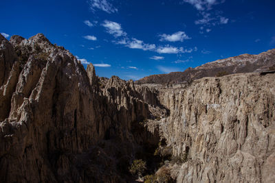 Low angle view of rocky mountains against sky