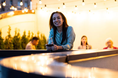 Portrait of young woman sitting on table