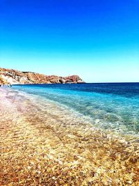 Scenic view of beach against clear blue sky