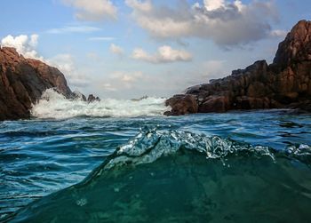 Scenic view of rocks in sea against sky