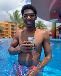 Portrait of shirtless man swimming in pool