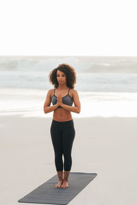 Portrait of young woman standing at beach