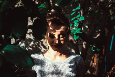 Beautiful woman standing with leaves shadow