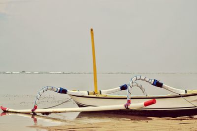 Boat moored in sea against sky