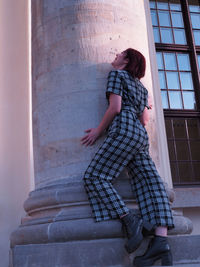 Full length of woman on window of building