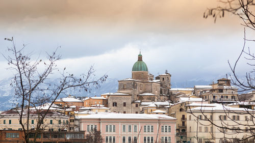 View of cityscape against cloudy sky