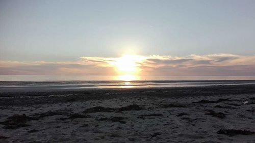 Scenic view of beach against sky during sunset