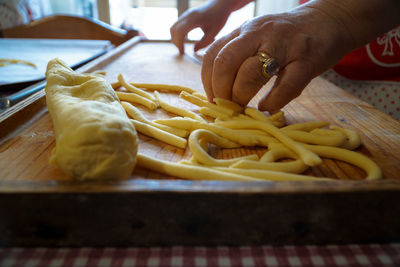 Cropped hands of woman preparing food on table