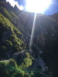 Scenic view of waterfall and mountains against sky