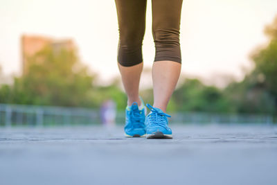 Low section of woman walking on footpath