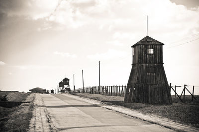 Road amidst field against sky