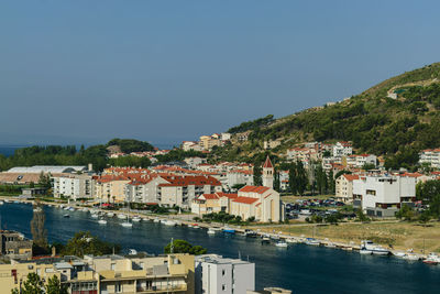 Town by sea against clear blue sky