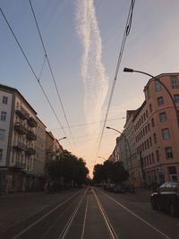 Road in city against sky at sunset