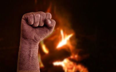 Close-up of man hand on fire