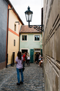 People in alley amidst buildings