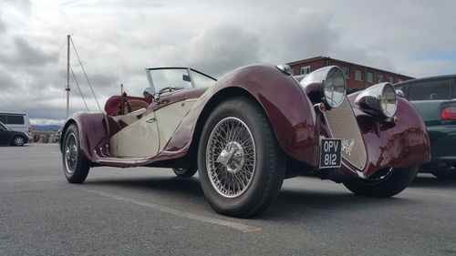 Vintage car on road against sky in city