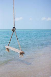 Wood swing scenic view of sea against sky