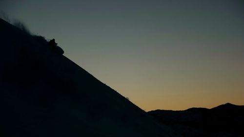 Low angle view of silhouette mountain against clear sky