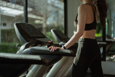 Midsection of woman standing on exercise equipment