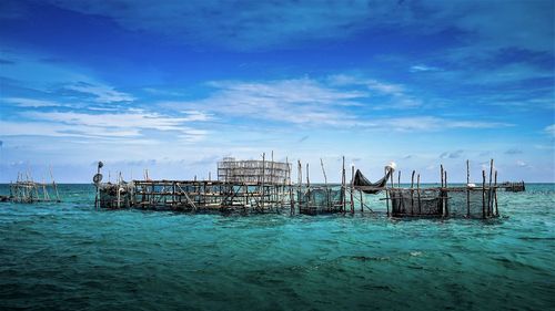 Pier over sea against blue sky