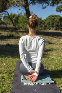 Woman doing yoga poses with arms behind her back in nature