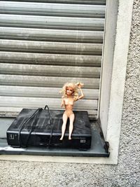 Abandoned doll with dvd player against shutter