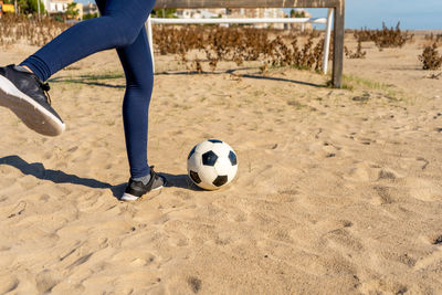 Low section of man playing soccer on field