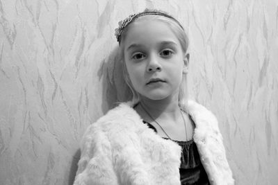 Close-up portrait of cute girl against wall