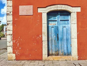 A blue door against a red wall in valladolid, mexico