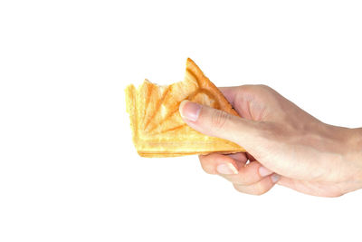Close-up of hand holding ice cream over white background