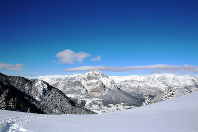 Scenic view of snow mountains against blue sky