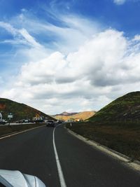 Road leading towards mountain against sky