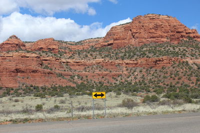 Yellow road by mountain against sky