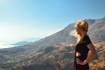 Woman standing on mountain against clear sky