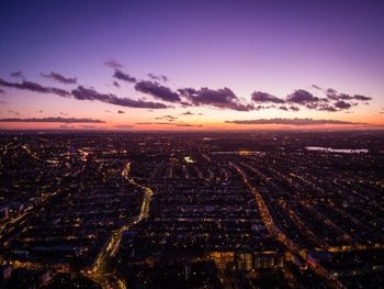 High angle view of illuminated buildings in city at sunset