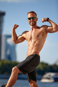 Low angle view of shirtless man exercising against sky