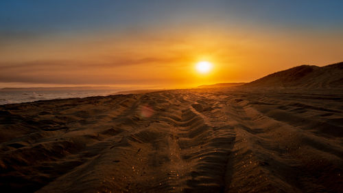 Scenic view of desert against sky during sunset