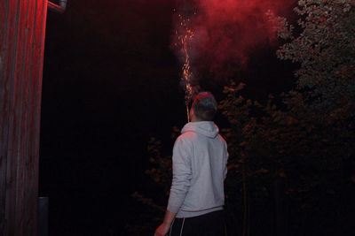 Rear view of man standing at night