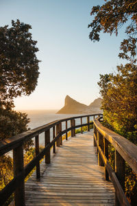 Footpath by sea against clear sky