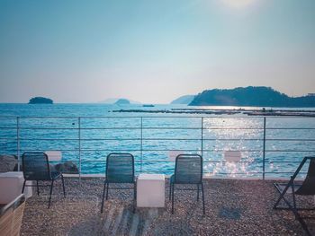 Chairs and tables against sea 