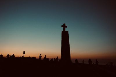 Silhouette lighthouse against sky during sunset